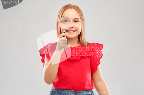 Image of happy girl looking through magnifying glass