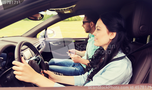 Image of happy man and woman driving in car