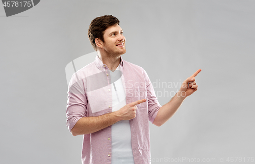 Image of smiling young man showing something