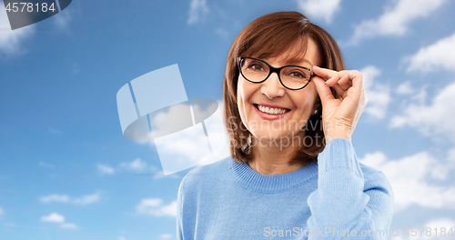 Image of portrait of senior woman in glasses over grey