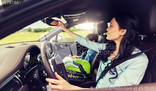 Image of happy woman with little child driving in car