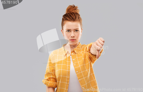 Image of angry red haired teenage girl showing thumbs down