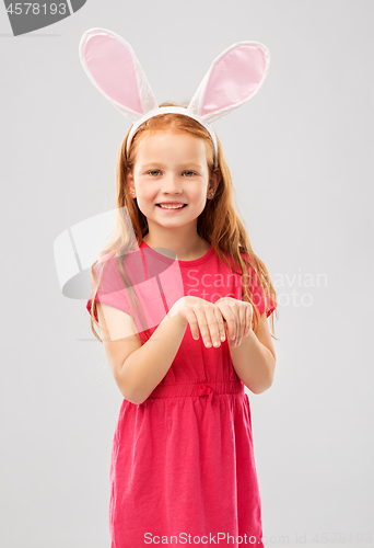Image of happy red haired girl wearing easter bunny ears