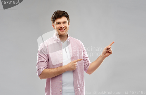 Image of smiling young man showing something