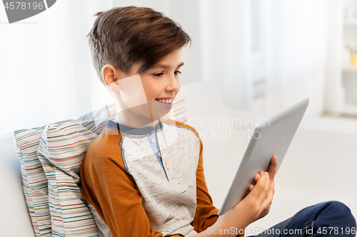 Image of smiling boy with tablet pc computer at home