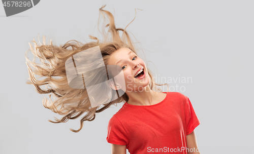 Image of smiling teenage girl in red with long wavy hair