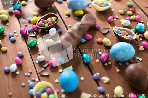 Image of chocolate eggs, easter bunny and candies on wood