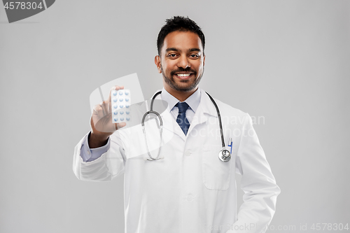 Image of indian male doctor with pills and stethoscope