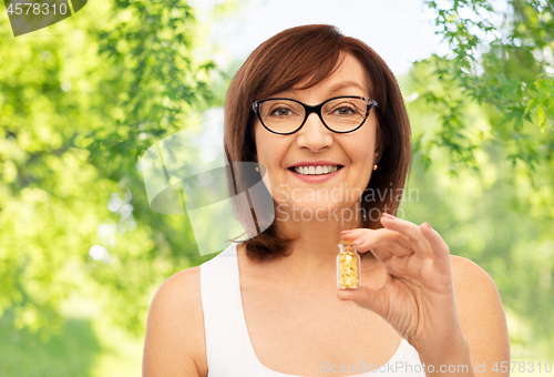 Image of senior woman with gold facial mask in bottle