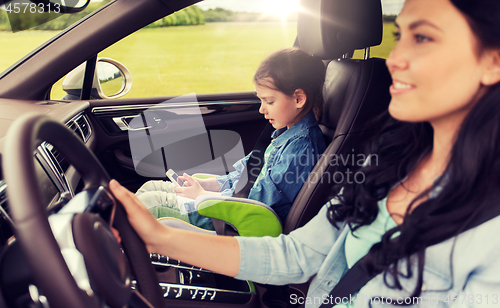 Image of happy woman with little child driving in car