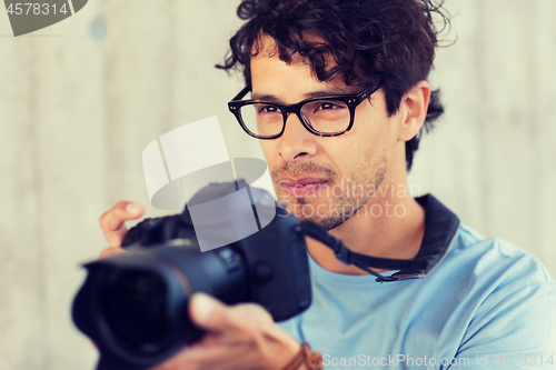 Image of photographer with digital camera shooting in city