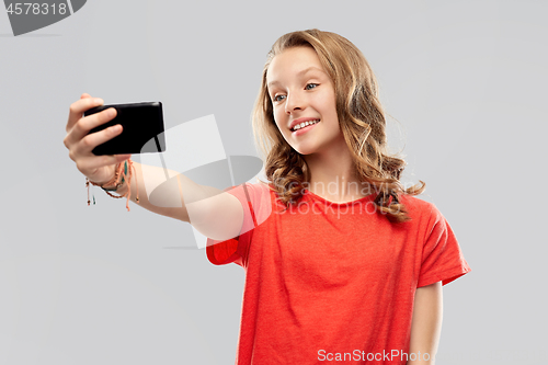 Image of smiling teenage girl taking selfie by smartphone