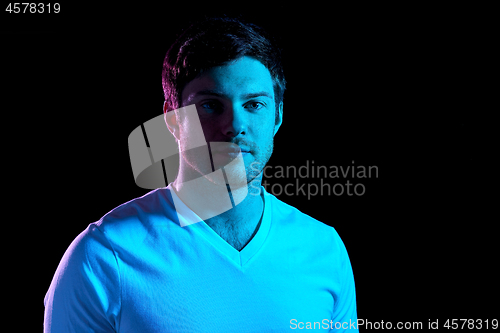 Image of portrait of man over neon lights in dark room