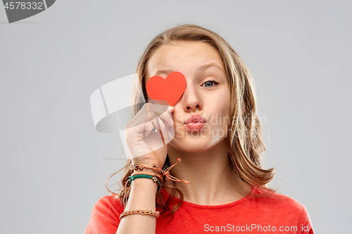 Image of teenage girl covering eye with red heart