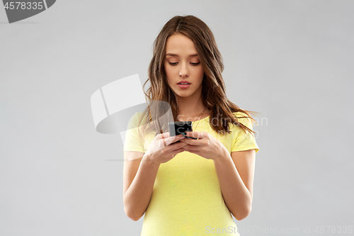 Image of young woman or teenage girl using smartphone