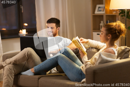 Image of couple with laptop computer and book at home