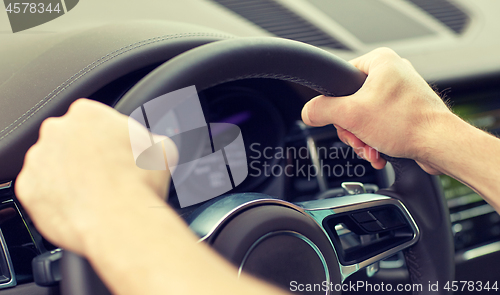 Image of close up of male hands driving car