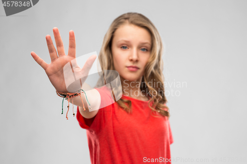 Image of serious teenage girl showing stop gesture