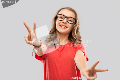 Image of smiling student girl in glasses showing peace