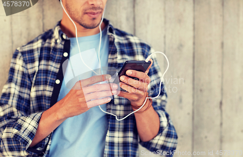 Image of man with earphones and smartphone listening music