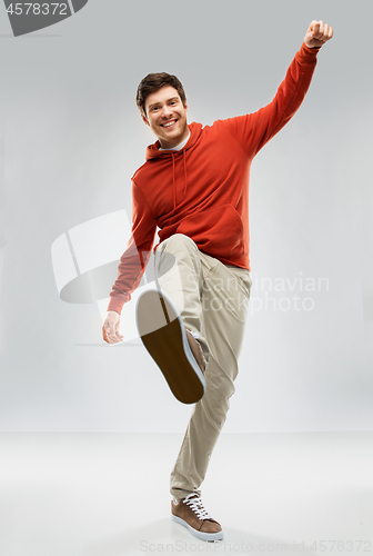 Image of happy young man in hoodie stepping up