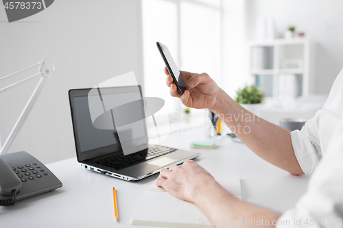 Image of businessman using smartphone at office