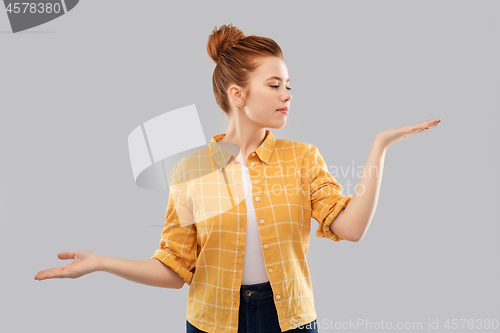 Image of red haired teenage girl holding empty hands