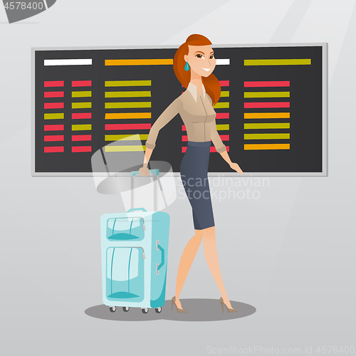 Image of Caucasian woman walking with suitcase at airport.