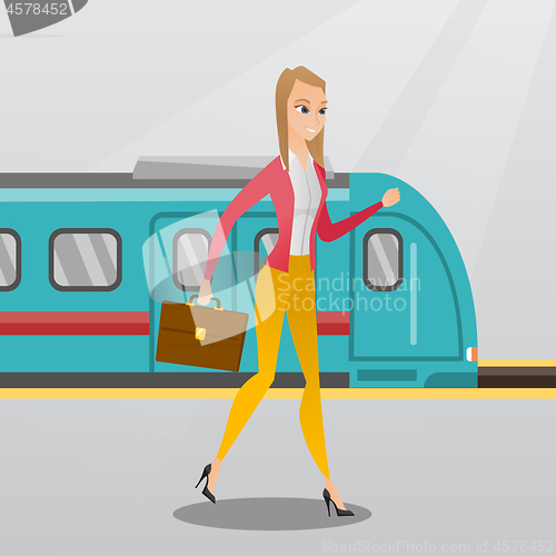 Image of Young woman walking on a railway station platform.