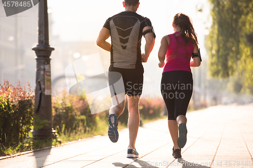 Image of young couple jogging  in the city