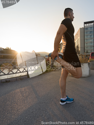 Image of athlete man warming up and stretching