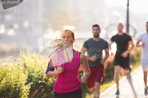 Image of group of young people jogging in the city