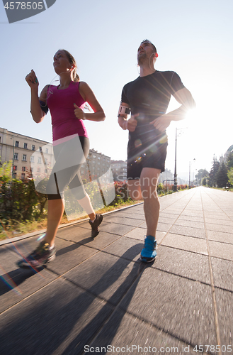 Image of young couple jogging  in the city