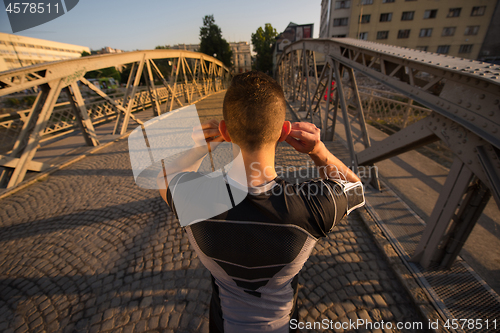 Image of portrait of a jogging man at sunny morning