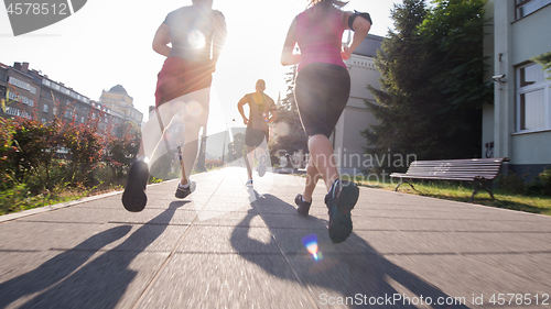 Image of group of young people jogging in the city