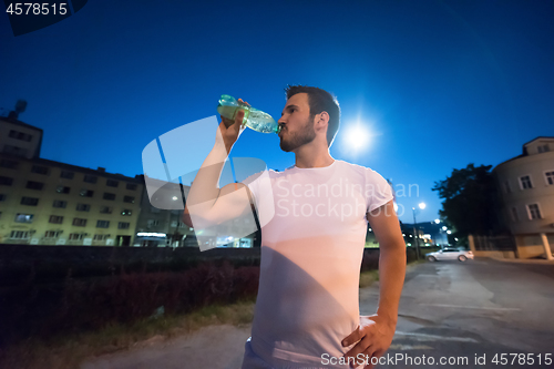 Image of man drinking water after running session