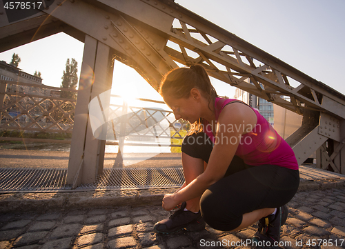 Image of woman tying running shoes laces