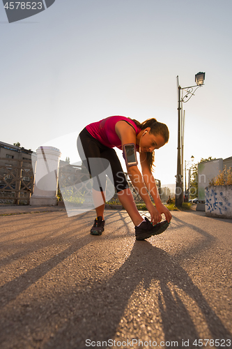 Image of athlete woman warming up and stretching