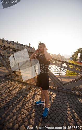 Image of portrait of a jogging man at sunny morning