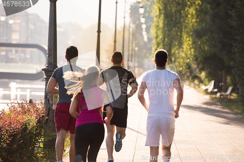 Image of group of young people jogging in the city