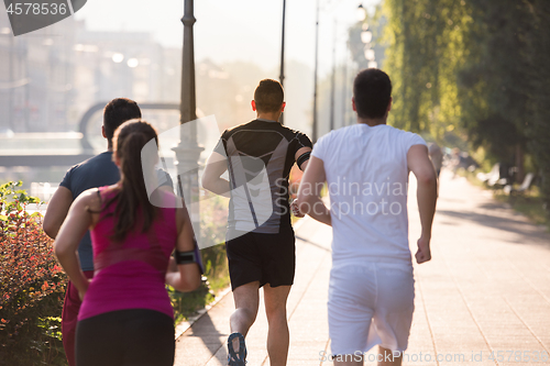 Image of group of young people jogging in the city