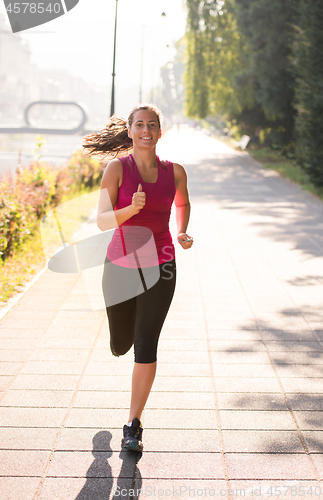 Image of woman jogging at sunny morning