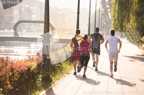 Image of group of young people jogging in the city