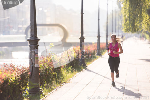 Image of woman jogging at sunny morning