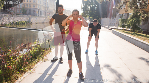 Image of group of young people jogging in the city