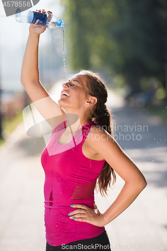 Image of woman pouring water from bottle on her head