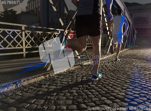 Image of young people jogging across the bridge