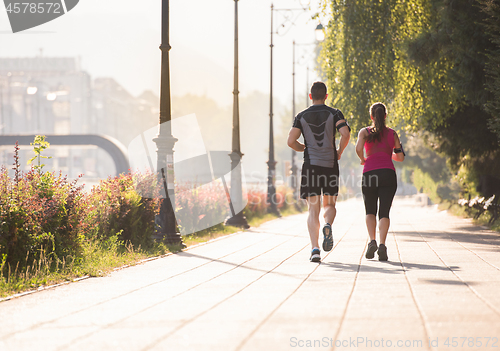 Image of young couple jogging  in the city