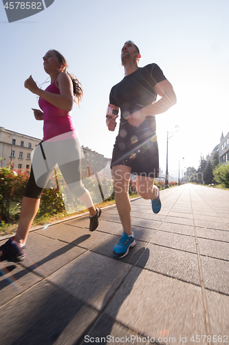 Image of young couple jogging  in the city