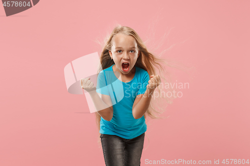 Image of Portrait of angry teen girl on a pink studio background